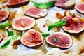 Italian fast food. Delicious hot fruit pizza with figs sliced and served on wooden platter with ingredients, close up view. Menu p Royalty Free Stock Photo
