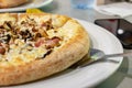 Italian fast food, delicious hot pizza with bacon and mushrooms sliced and served on a white plate, close up Royalty Free Stock Photo