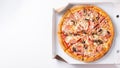 Italian fast food. Delicious hot pizza in a box with ham and champignons sliced and served on brown white table, close up view. Royalty Free Stock Photo