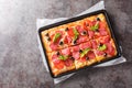 Italian fast food rectangular pizza with mozzarella, salami sausage, olives and tomatoes close-up in a baking sheet. horizontal Royalty Free Stock Photo