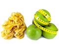 Italian fettuccine nest pasta and apple with a measuring tape.Still-life on a white background