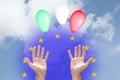 Italian financial Euro crisis concept: three balloons with Italian flag colors rising up to the sky, two hands and the European U