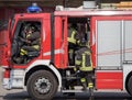 Italian firefighters climb on firetrucks