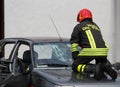 Italian fireman while breaks the glass windshield broken car