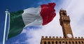 The Italian flag waving in the wind with the tower of Palazzo Vecchio in Florence in the background