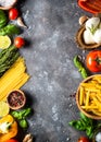 Italian food background. Pasta, herbs, vegetables on black top v Royalty Free Stock Photo