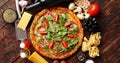 Italian food background with pizza, raw pasta and vegetables on wooden table Royalty Free Stock Photo