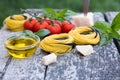 Italian food background with tomatoes, basil, spaghetti, parmesan, olive oil. Ingredients on old wooden table. Royalty Free Stock Photo