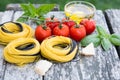 Italian food background with tomatoes, basil, spaghetti, parmesan, olive oil. Ingredients on old wooden table. Royalty Free Stock Photo