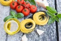 Italian food background with tomatoes, basil, spaghetti, parmesan, olive oil. Ingredients on old wooden table. Royalty Free Stock Photo