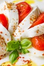 Italian food: Caprese salad with sliced mozzarella, tomato, fresh basil, herbs and olive oil Royalty Free Stock Photo