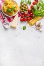 Italian food cuisine and ingredients on white concrete table. Spaghetti Tagliatelle olives olive oil tomatoes parmesan cheese.