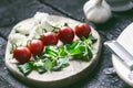 Italian food, cuisine. Margherita pizza on a black, wooden table with igredients like tomatoes, salad, cheese, mozzarella, basil. Royalty Free Stock Photo