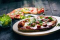 Italian food, cuisine. Margherita pizza on a black, wooden table with igredients like tomatoes, salad, cheese, mozzarella, basil. Royalty Free Stock Photo