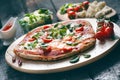 Italian food, cuisine. Margherita pizza on a black, wooden table with igredients like tomatoes, salad, cheese, mozzarella, basil. Royalty Free Stock Photo