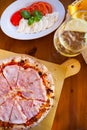 Italian food dinner. Pizza with tomato prosciutto mozzarella glass white wine summer outdoor restaurant Royalty Free Stock Photo