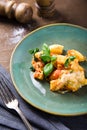 Italian food. Gnocchi with cheese and basil in handmade on a green plate on the old wooden table, near the vintage fork and knife Royalty Free Stock Photo