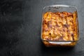 Italian Food. Hot Tasty Freshly Baked Lasagna, in baking tray, on black stone background, with copy space for text Royalty Free Stock Photo