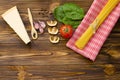 Italian food ingredients: pasta, tomato, spinach, pepper, porcini on wooden background Royalty Free Stock Photo