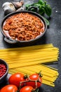 Italian food ingredients for Spaghetti Bolognese. Raw pasta, Basil, ground beef, tomatoes. Black background. Top view Royalty Free Stock Photo