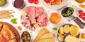 Italian food panorama. Pizza, cheese, ham, wine, olives, capers, shot from above Royalty Free Stock Photo