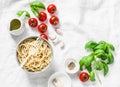 Italian food pasta background with copy space on white background, top view. Basil, whole grain spaghetti, cherry tomatoes, olive Royalty Free Stock Photo