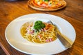 Italian food pasta with cheese sauce, Spaghetti carbonara with chopped bacon, cheese sauce on white dish and Pizza over wooden Royalty Free Stock Photo