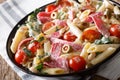 Italian food: penne pasta with salami, cheese, and vegetables cl Royalty Free Stock Photo