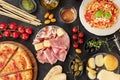 Italian food. Pizza, pasta, cheese, ham, wine, olives, pesto, olive oil, capers, shot from above with a place for text, a flat lay Royalty Free Stock Photo