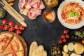 Italian food. Pizza, pasta, cheese, ham, wine, olives, pesto, olive oil, capers, shot from the top Royalty Free Stock Photo