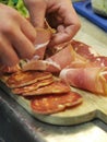 Italian food - Preparation of appetizer of Italian cold cuts, salami ham Royalty Free Stock Photo