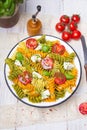 Italian food - Salad with colorful pasta, cherry tomatoes, feta cheese and fresh basil Royalty Free Stock Photo