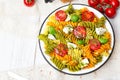 Italian food - Salad with colorful pasta, cherry tomatoes, feta cheese and fresh basil Royalty Free Stock Photo