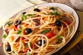 Italian food: spaghetti alla putanesca with anchovies, tomatoes, garlic, black olives and greens close-up. horizontal Royalty Free Stock Photo