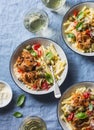 Italian food table. Pasta with slow cooker chicken with olives and sweet peppers, white wine. On a blue background Royalty Free Stock Photo