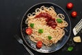 Italian food, traditional pasta spaghetti with tomato sauce, parmesan cheese and greens on a black stone background. Top view, Royalty Free Stock Photo