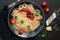 Italian food, traditional pasta spaghetti with tomato sauce, parmesan cheese and greens on a black stone background. View from Royalty Free Stock Photo