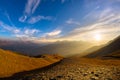 The Italian French Alps at sunset. Colorful sky over the majestic mountain peaks, dry barren terrain and green valleys. Sunburst a Royalty Free Stock Photo