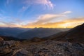 The Italian French Alps at sunset. Colorful sky over the majestic mountain peaks, dry barren terrain and green valleys. Sunburst a Royalty Free Stock Photo