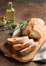 Italian fresh ciabatta bread cut  slices with rosemary and olive oil on wooden background. Close up and copy space Royalty Free Stock Photo