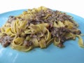 Italian fresh fettuccine or tagliatelle pasta with porcini mushrooms on a blue plate isolated on white background Royalty Free Stock Photo