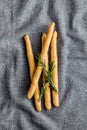 Italian grissini bread sticks and rosemary on kitchen tablecloth. Top view