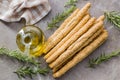 Italian grissini bread sticks with sesame seeds and rosemary on kitchen table. Top view