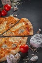 Italian homamade pizza with one piece and ingredients. Italian pizza on a dark gray black background