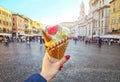 Italian ice - cream cone held in hand on the background of Piazza Navona in Rome , Italy Royalty Free Stock Photo