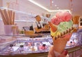 Italian ice - cream cone held in hand on the background of shop in Rome