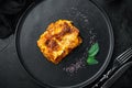 Italian Lasagne with tomato bolognese sauce and mince beef meat, on plate, on black stone background, top view, flat lay Royalty Free Stock Photo