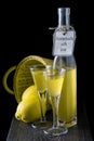 Italian limoncello in a shot glass on a black wooden background