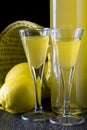 Italian limoncello in a shot glass on a black wooden background