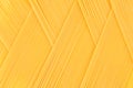 Italian long yellow spaghetti top view as zigzag abstract pattern background.